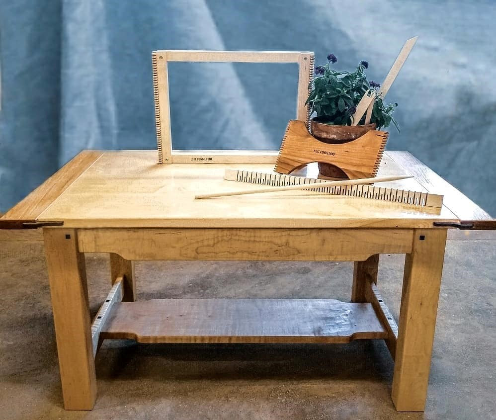 a small table top wooden weaving loom, heddle bar, weaving sword, needle, and small hand held loom.